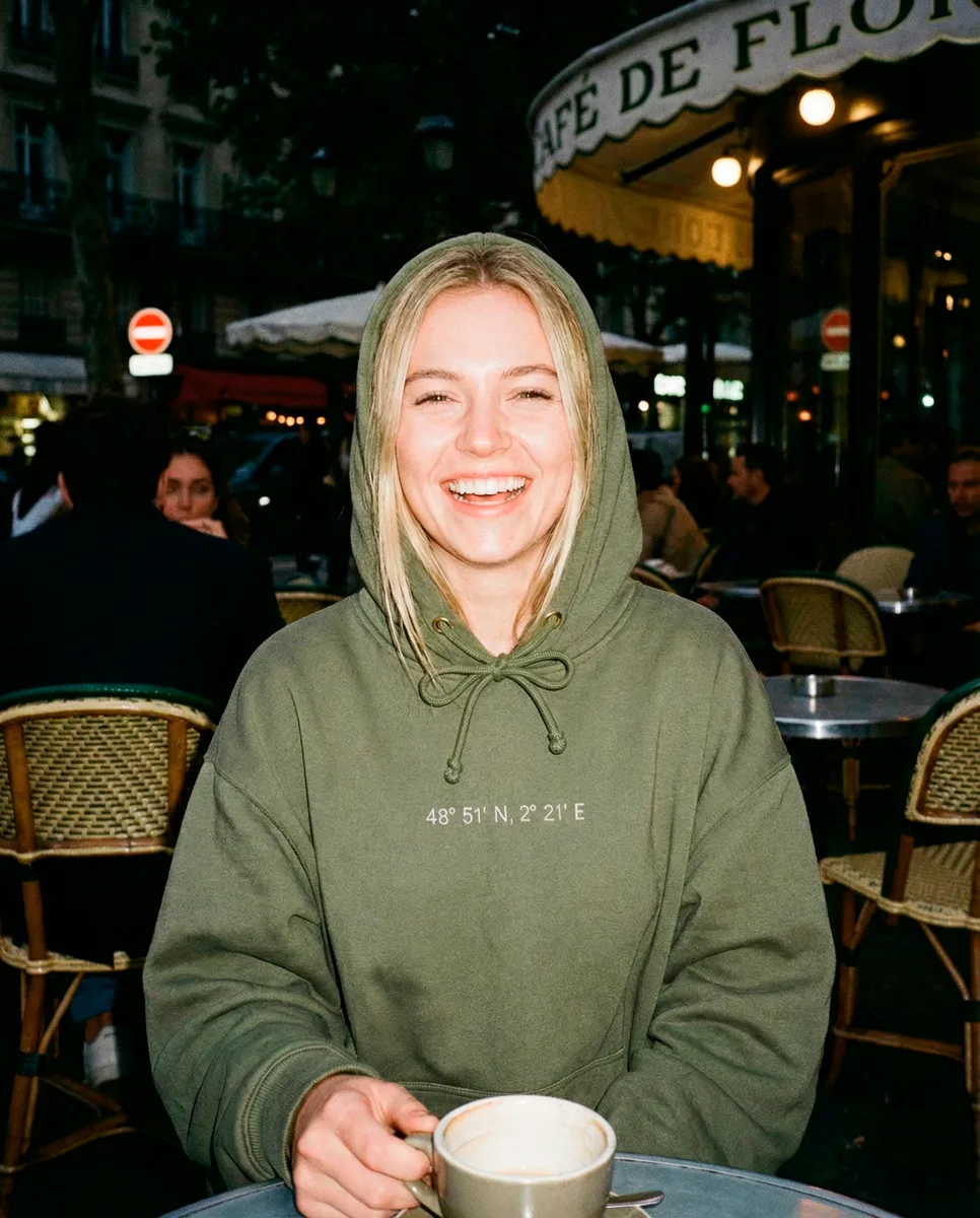 Modelo con sudadera militar green en cafetería parisina